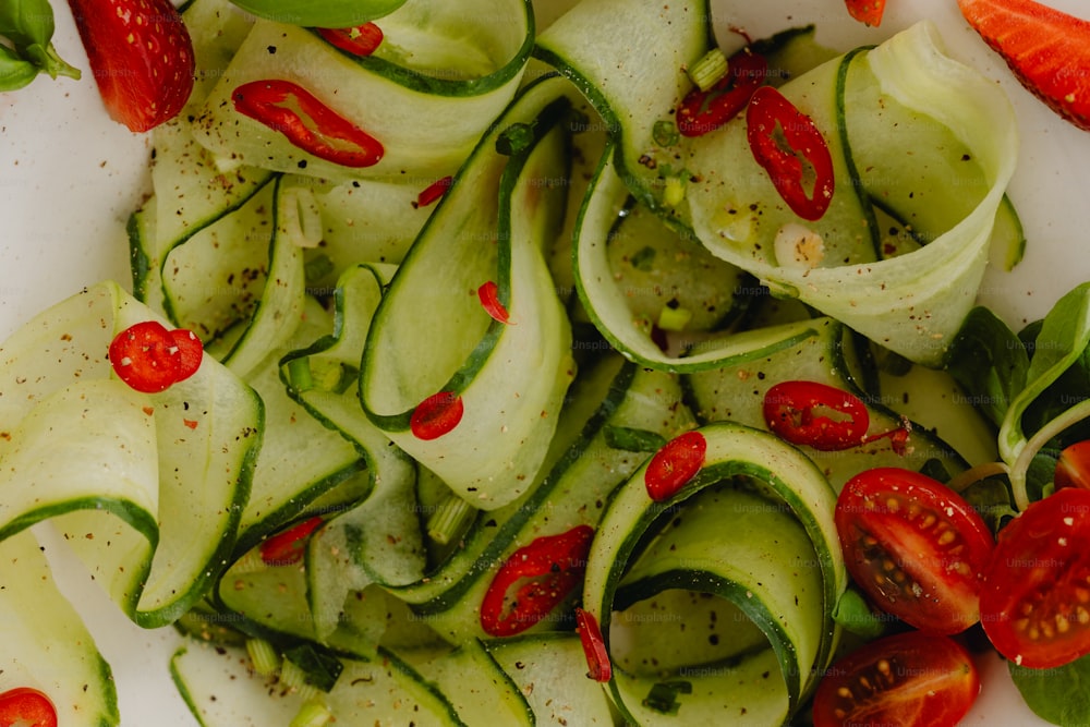 a white plate topped with sliced cucumbers and tomatoes