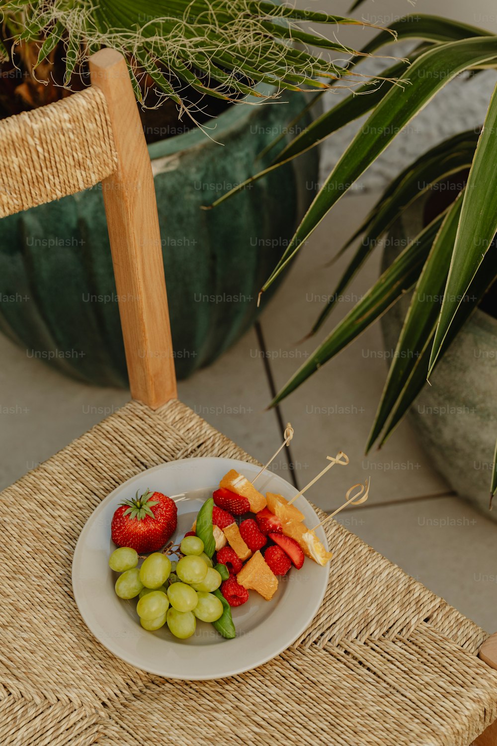 a plate of fruit on a wicker chair