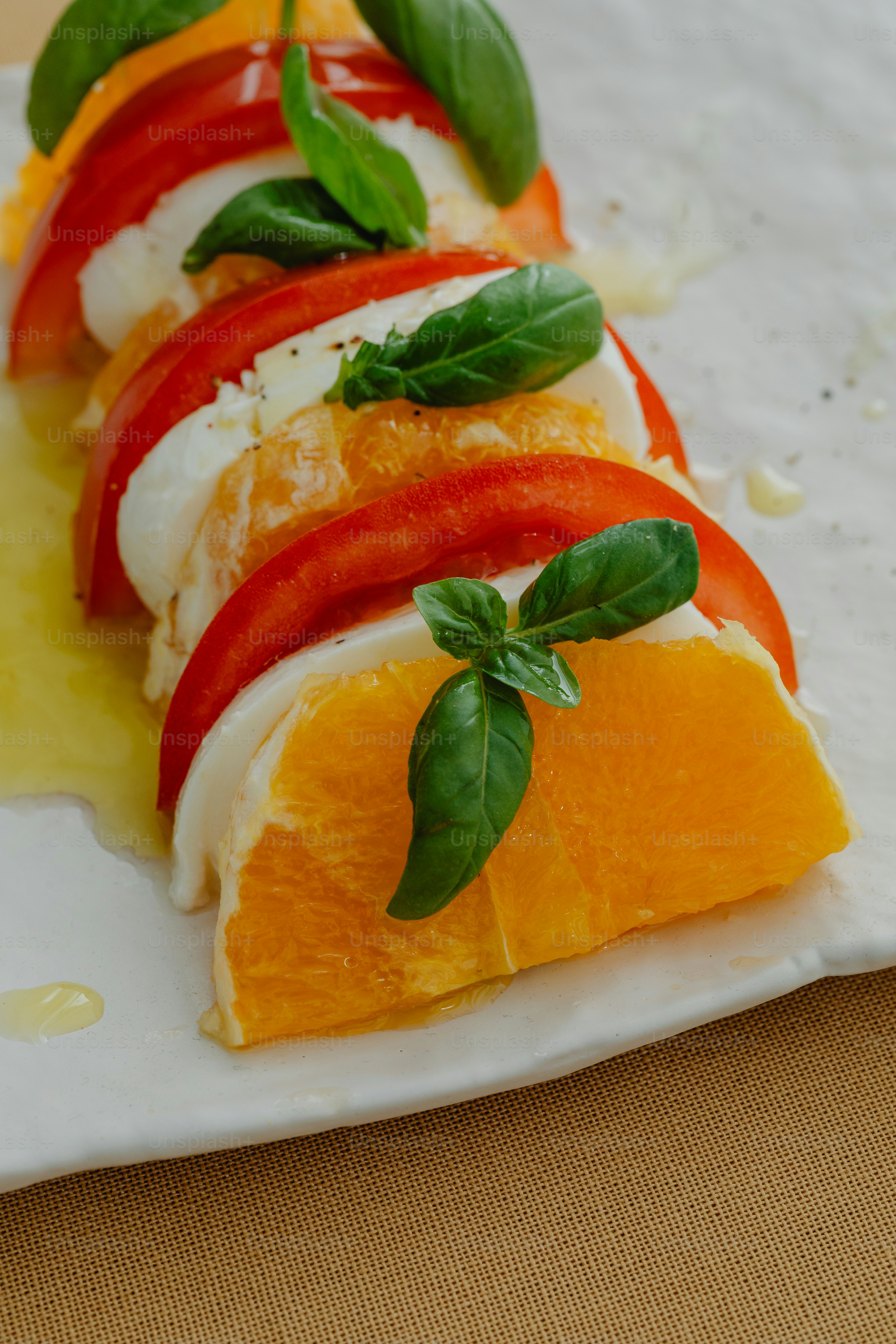 un piatto bianco sormontato da arance e verdure affettate
