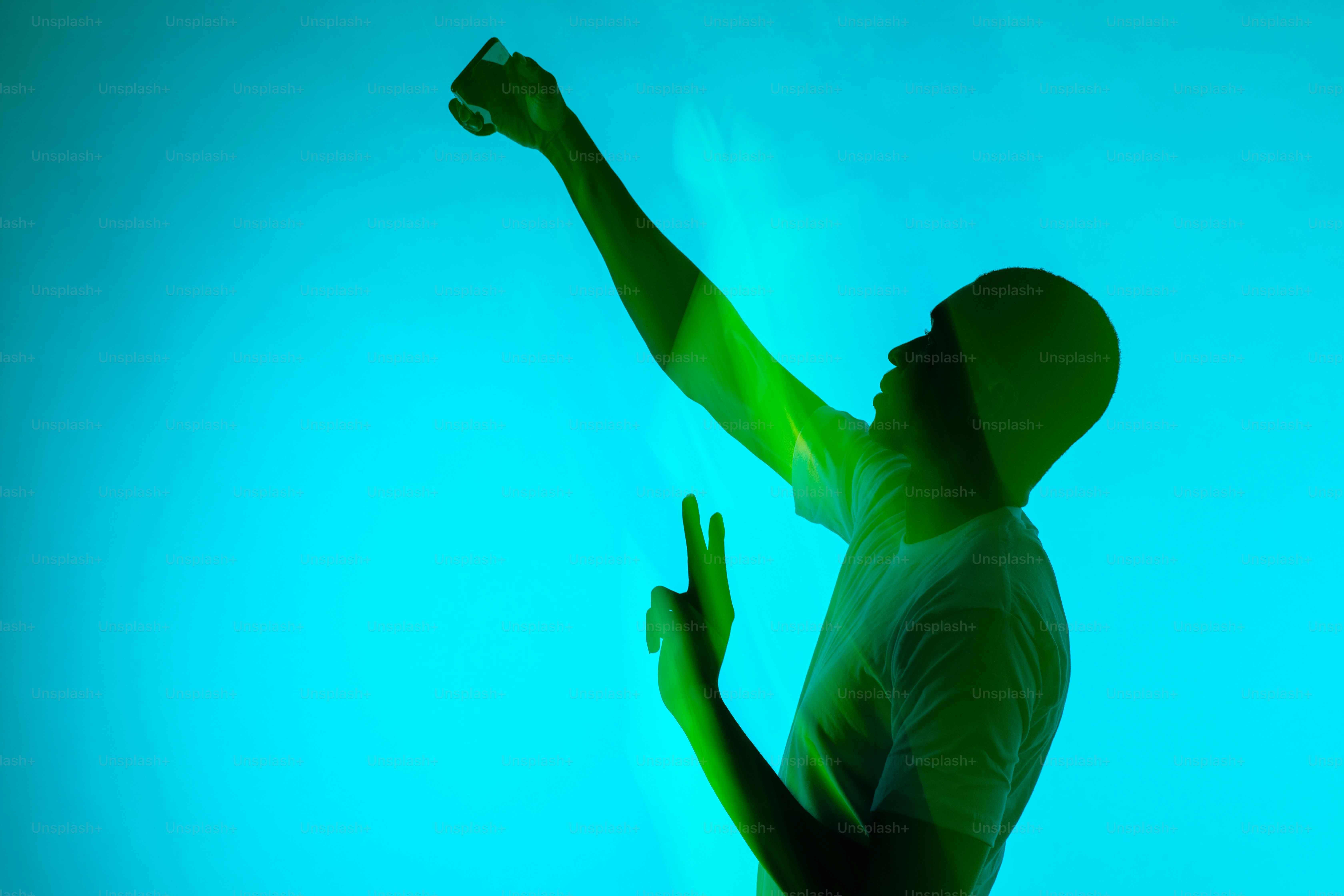 a silhouette of a man holding a cell phone