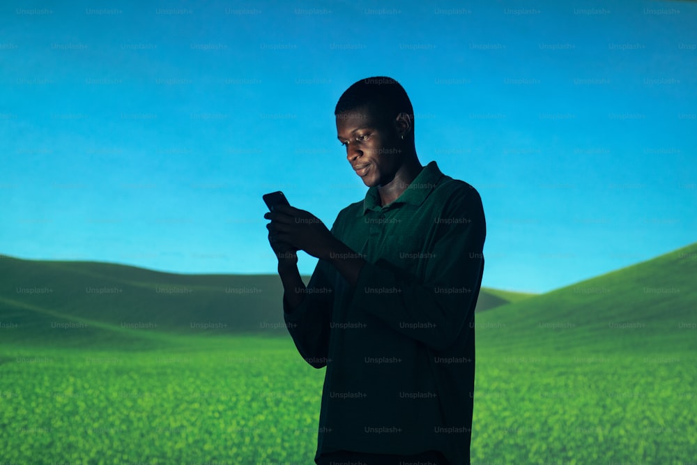 Un uomo in piedi davanti a uno schermo con in mano un telefono cellulare