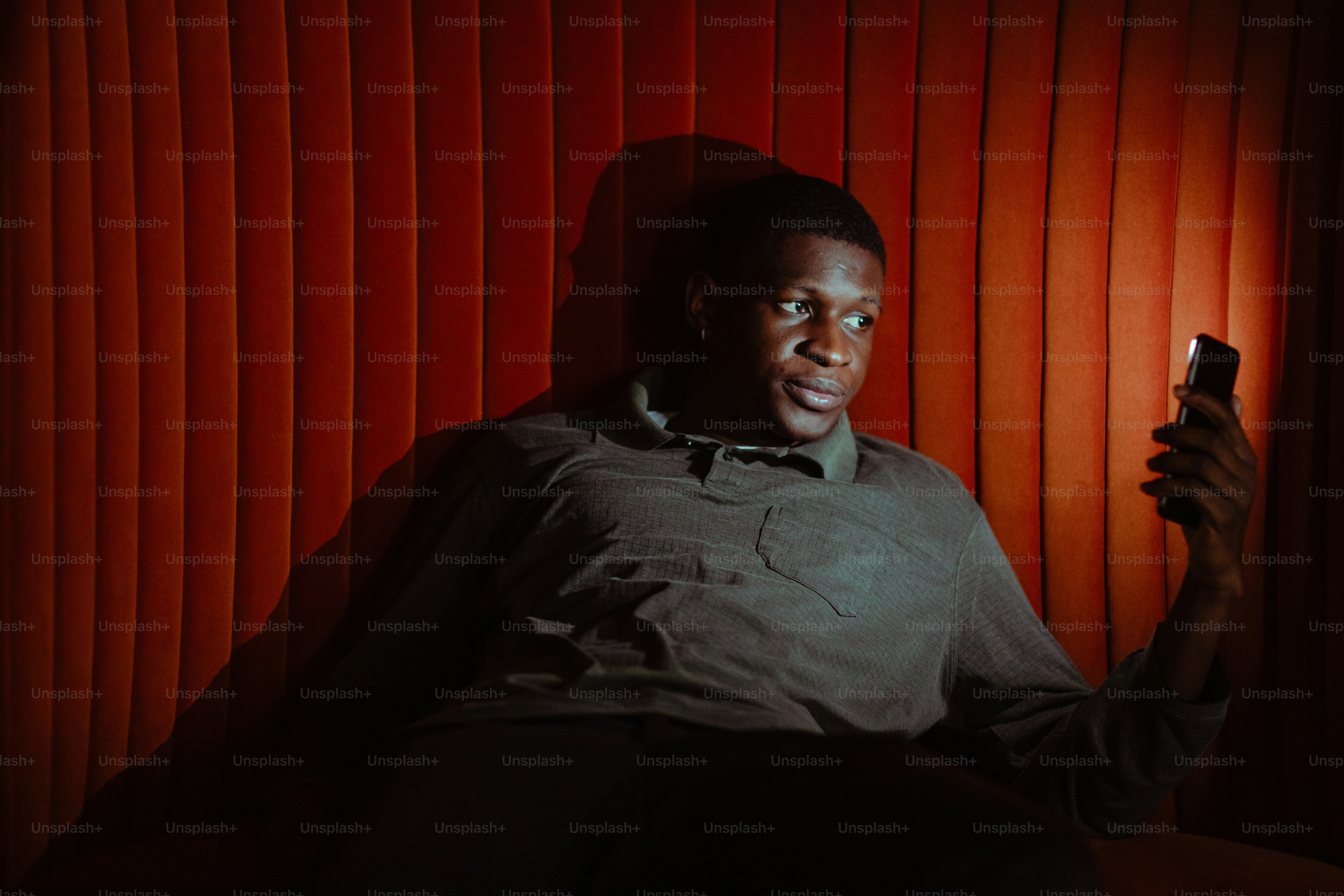 a man sitting in a chair holding a cell phone