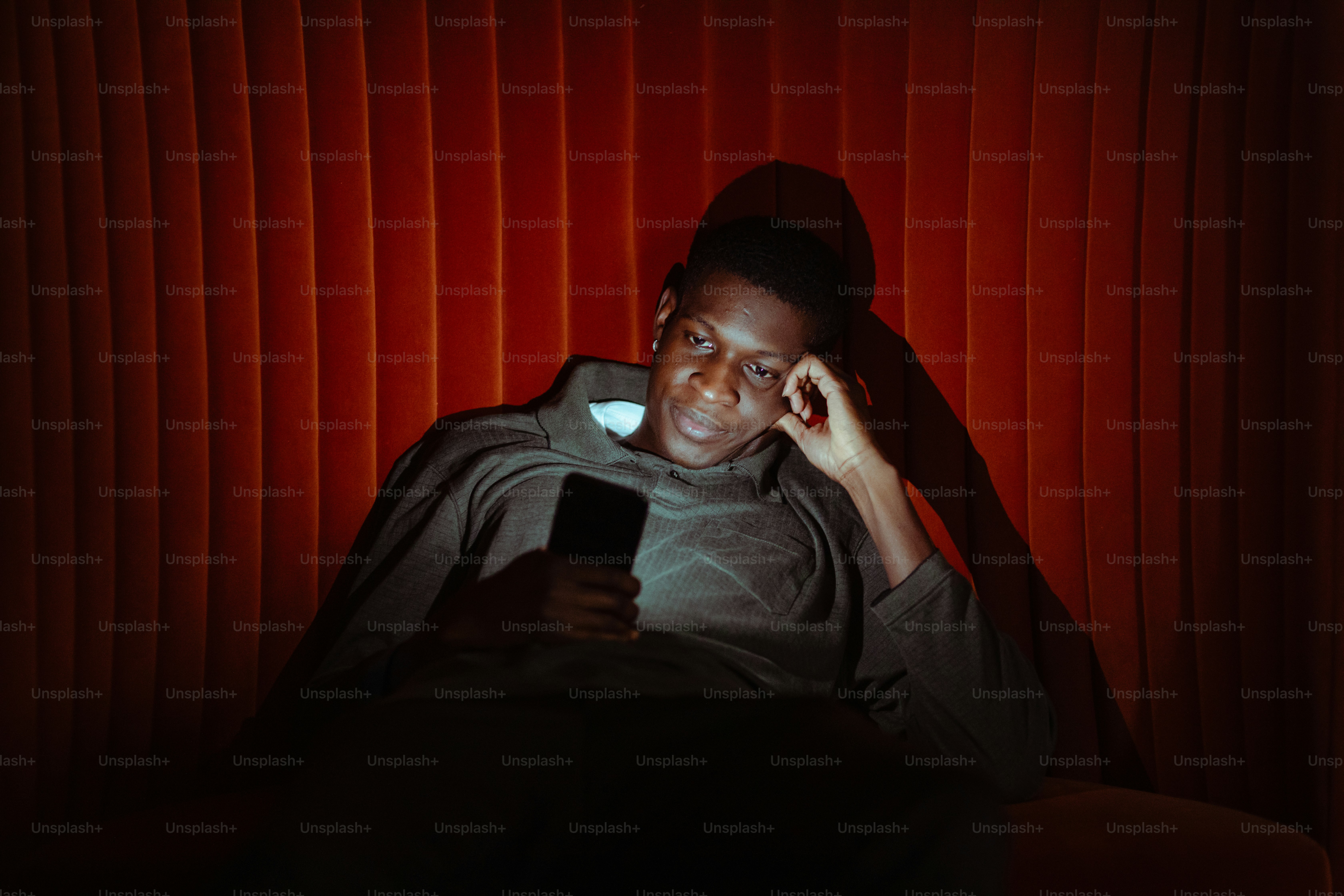 a man sitting in a chair while talking on a cell phone