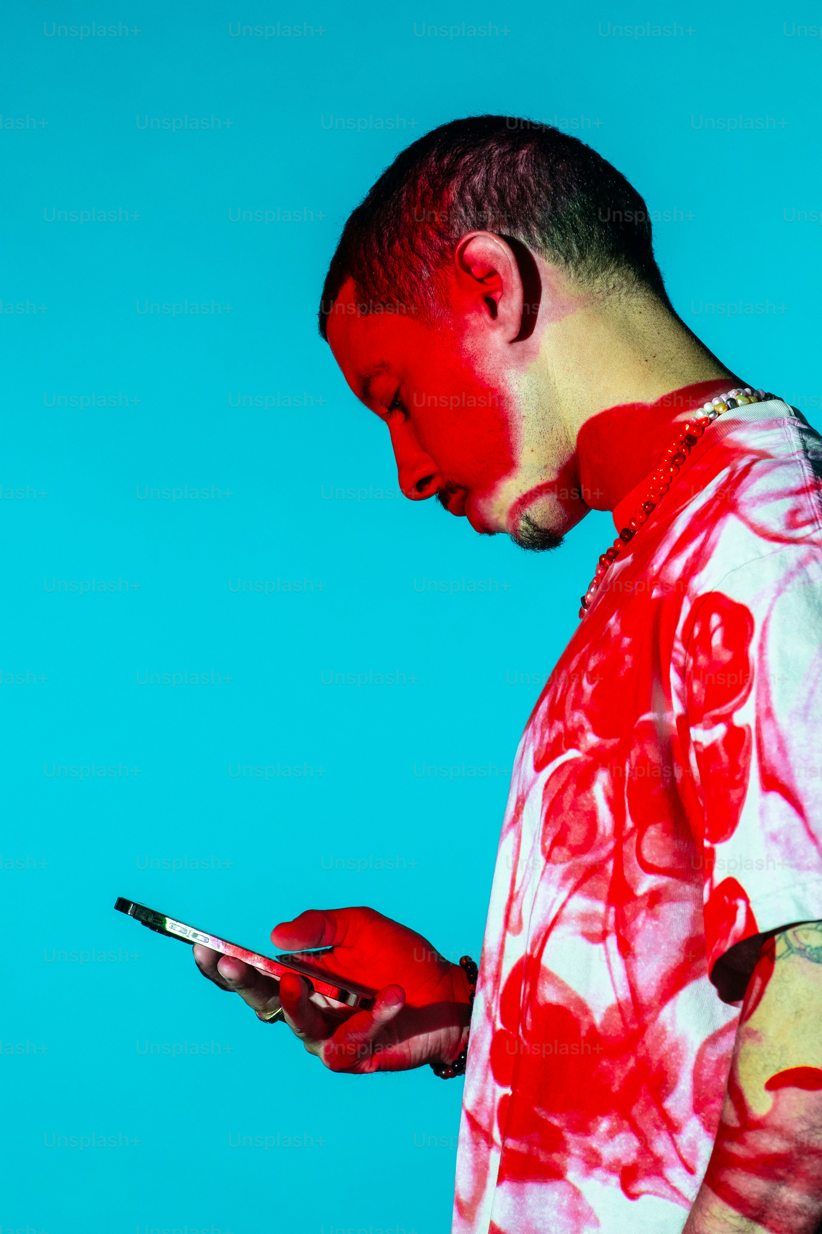 a man with red paint on his face using a cell phone