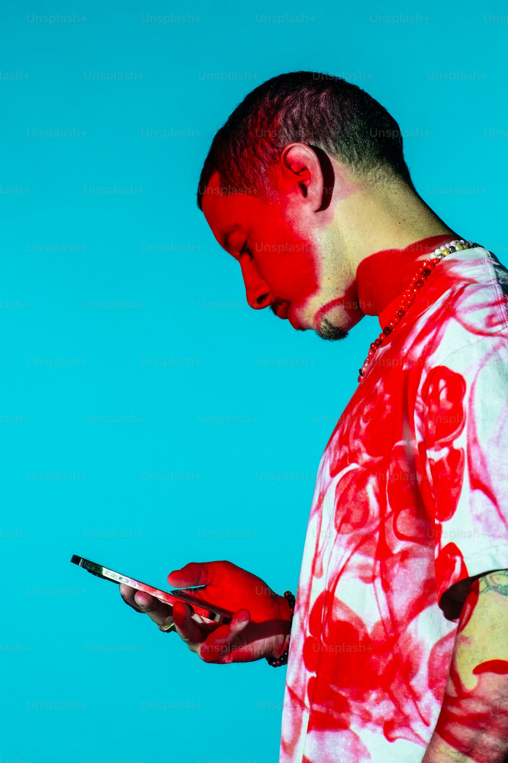 휴대폰을 사용하는 얼굴에 빨간 페인트를 칠한 남자