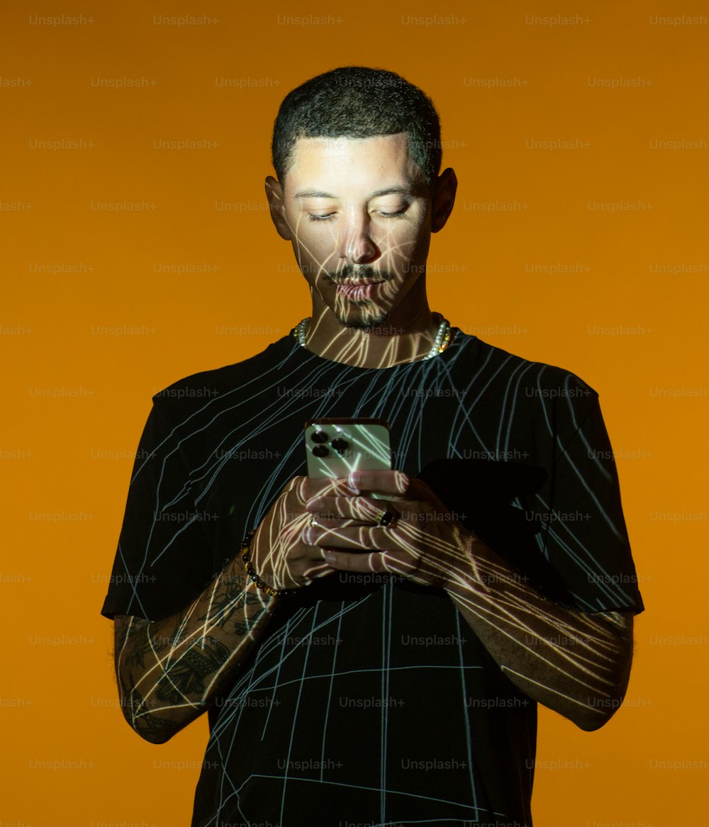 Un hombre con una camisa negra usando un teléfono celular