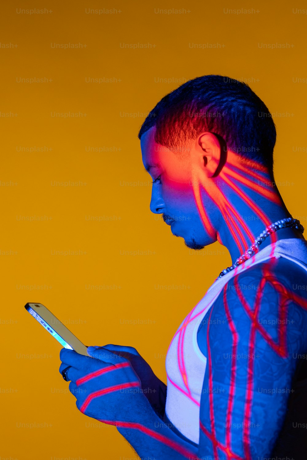 Una persona con una pintura corporal de neón sosteniendo un teléfono celular