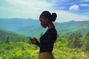Una mujer parada en un campo mirando su teléfono celular