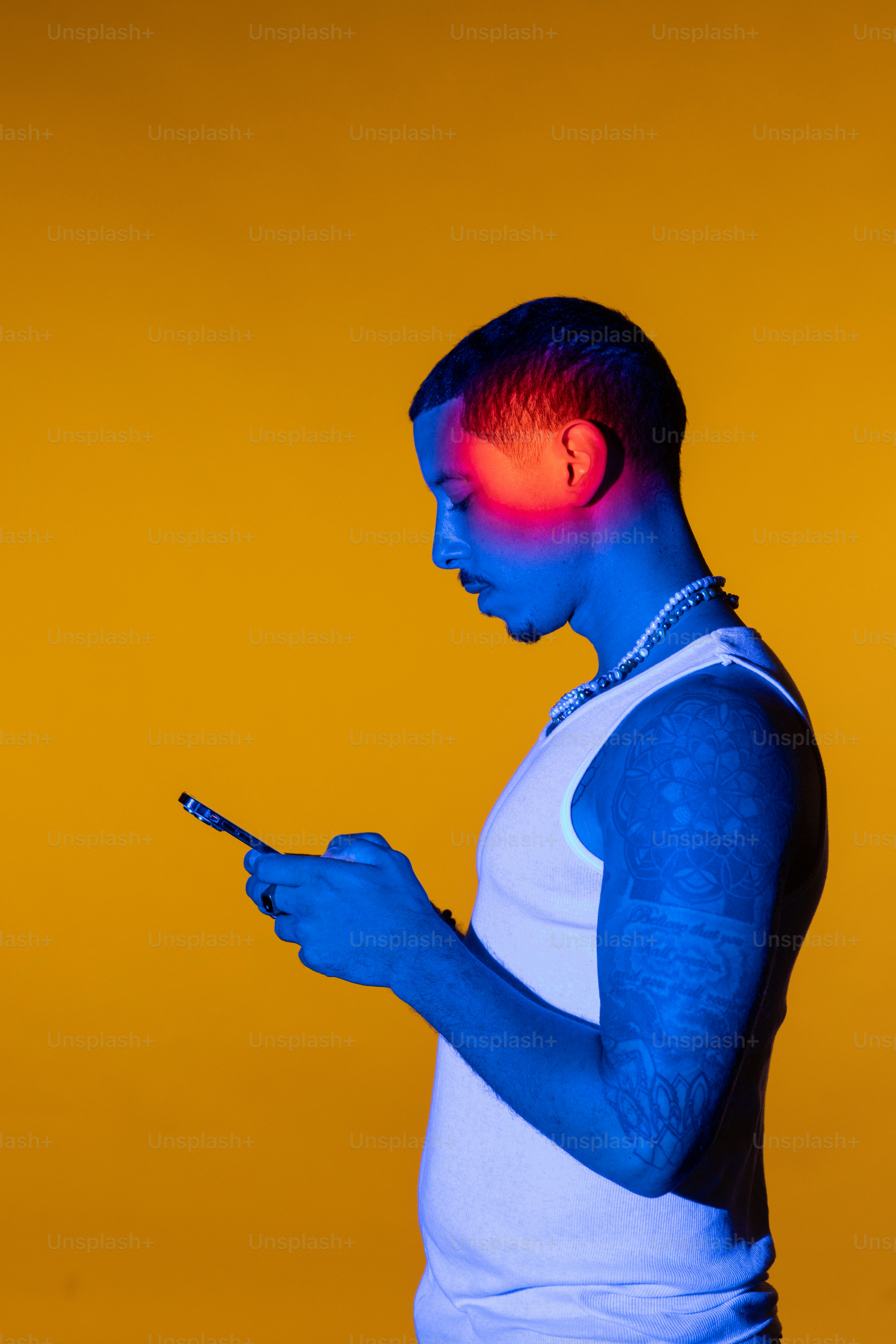 携帯電話を使うタンクトップの男