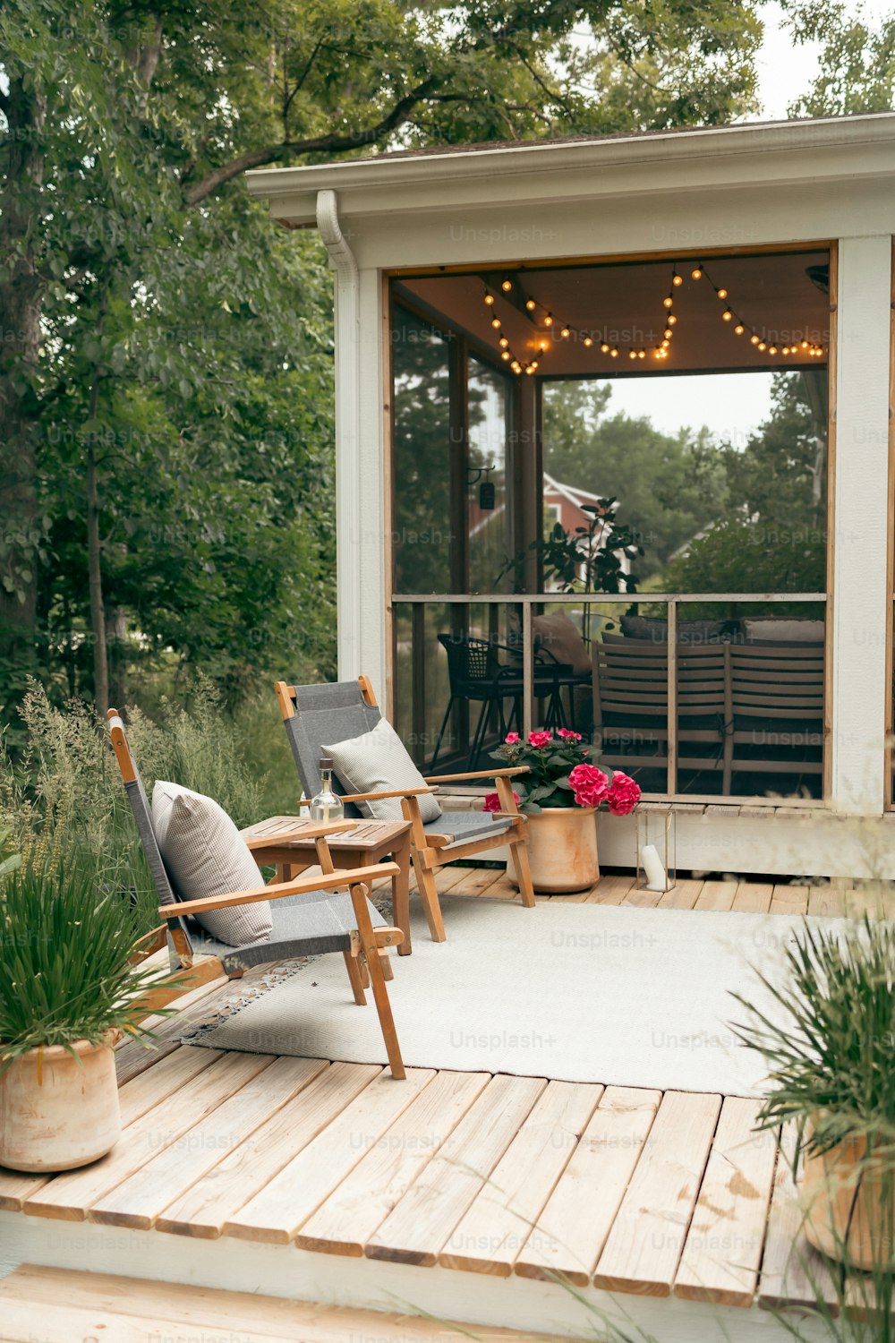 a deck with chairs and potted plants on it