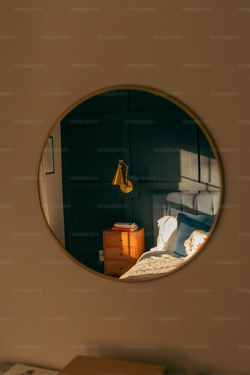 ein Spiegel, der ein Bett in einem Raum reflektiert