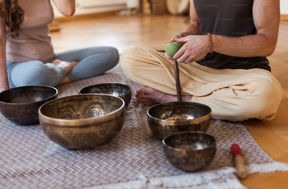 a couple of people sitting on the floor with bowls