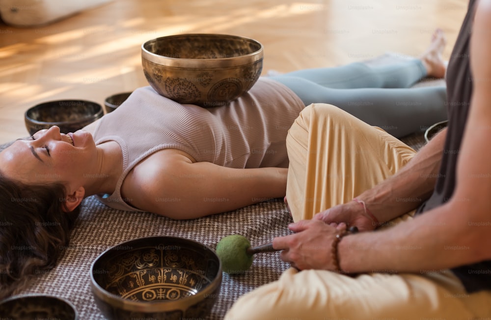 a woman laying on the floor with a bowl on her head