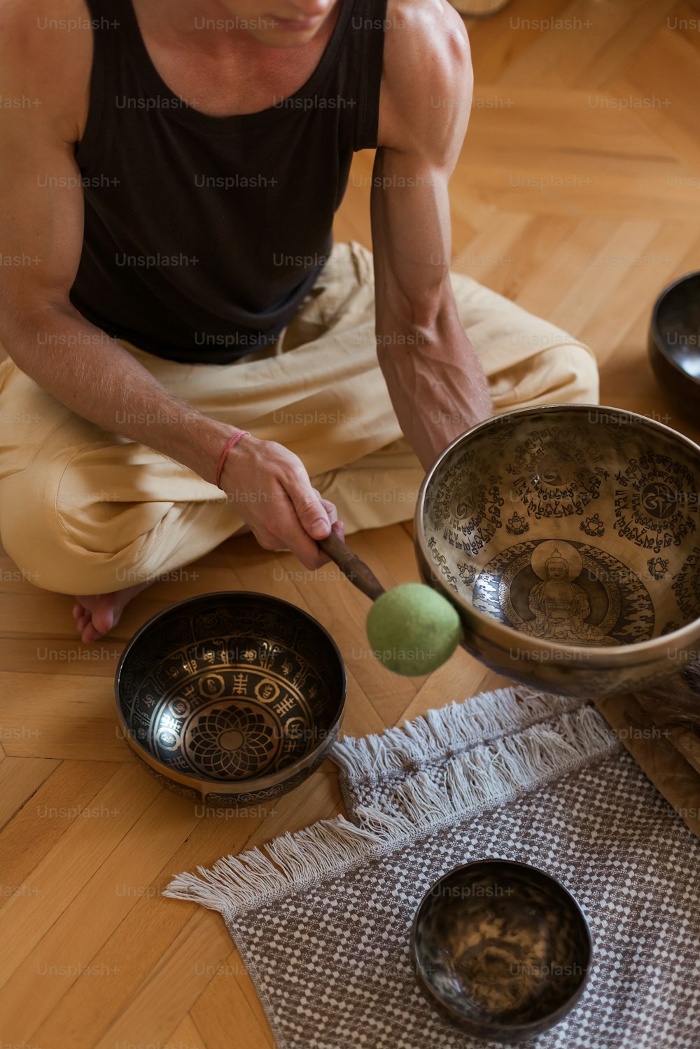 a man sitting on the floor playing with a metal bowl