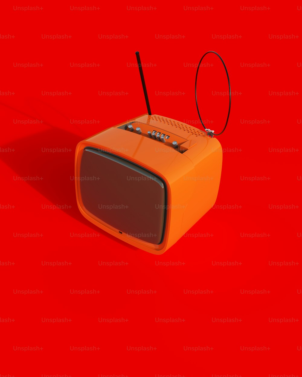 um rádio laranja sentado em cima de uma superfície vermelha