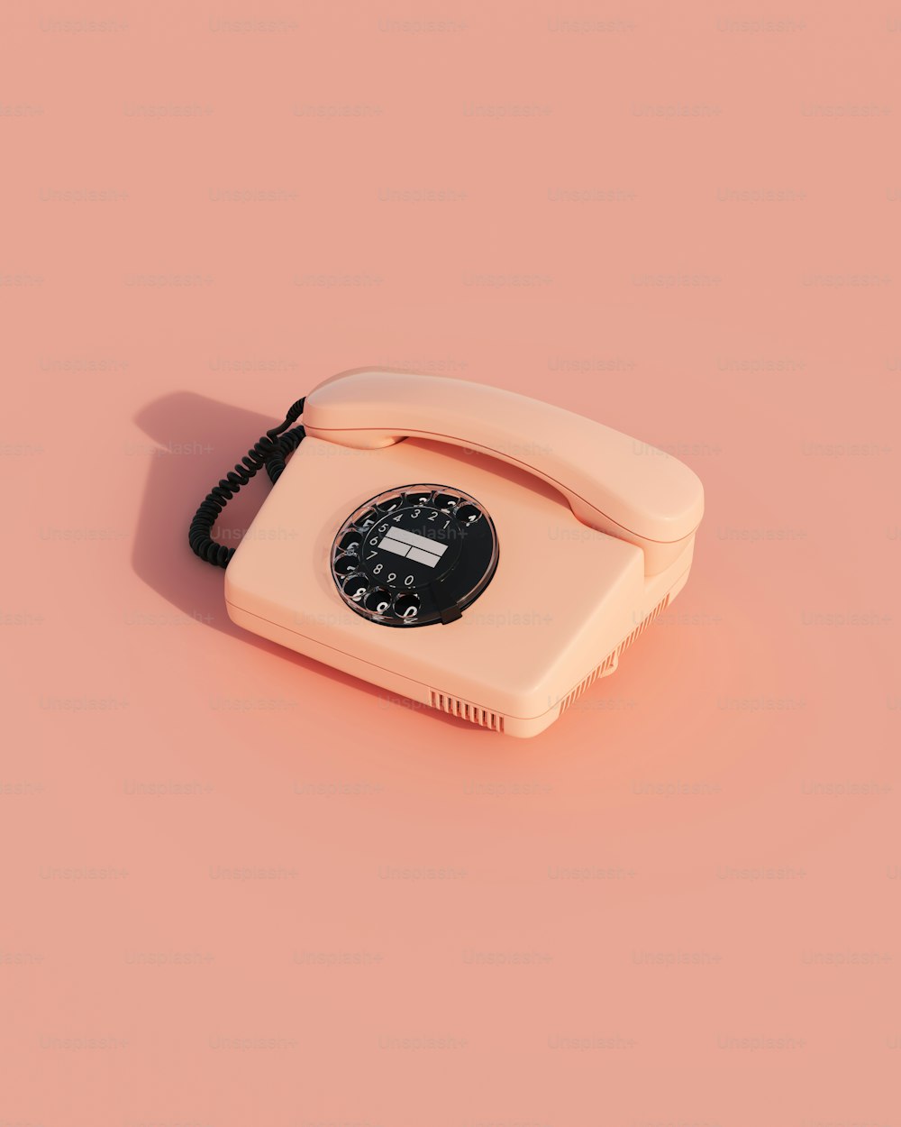 Un teléfono anticuado sobre un fondo rosa