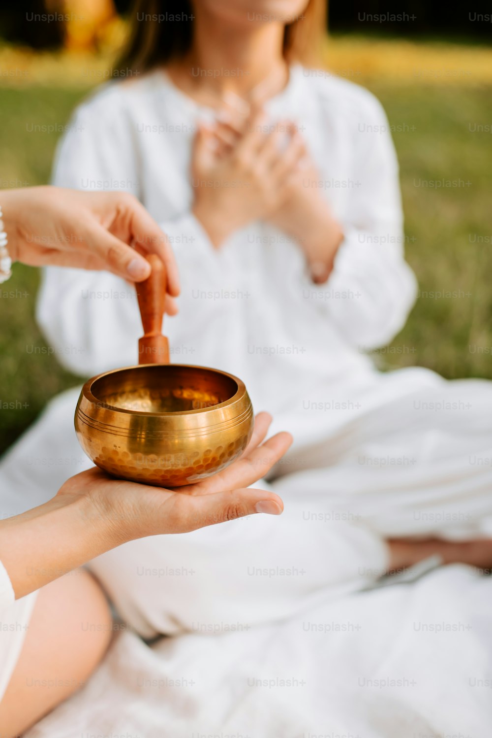 a woman holding a golden singing bowl in her hands