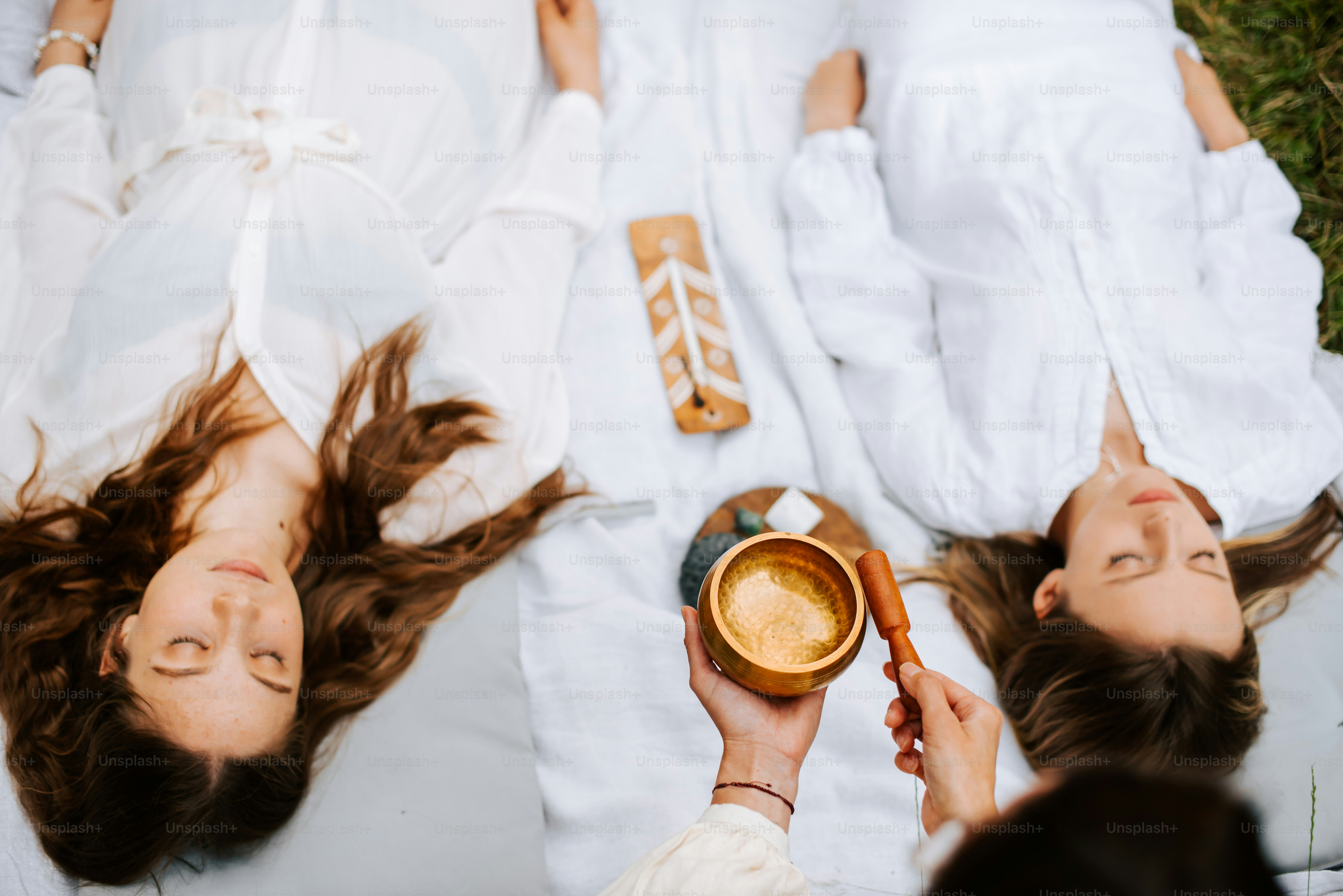 a couple of women laying on top of a bed next to each other