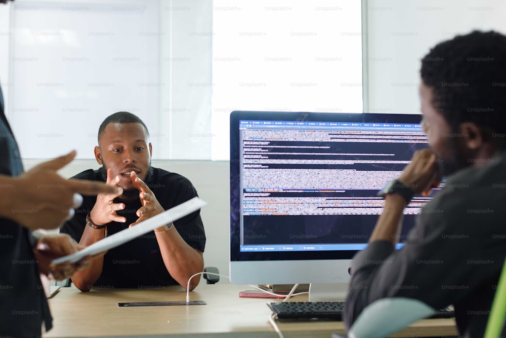 a group of people sitting around a computer