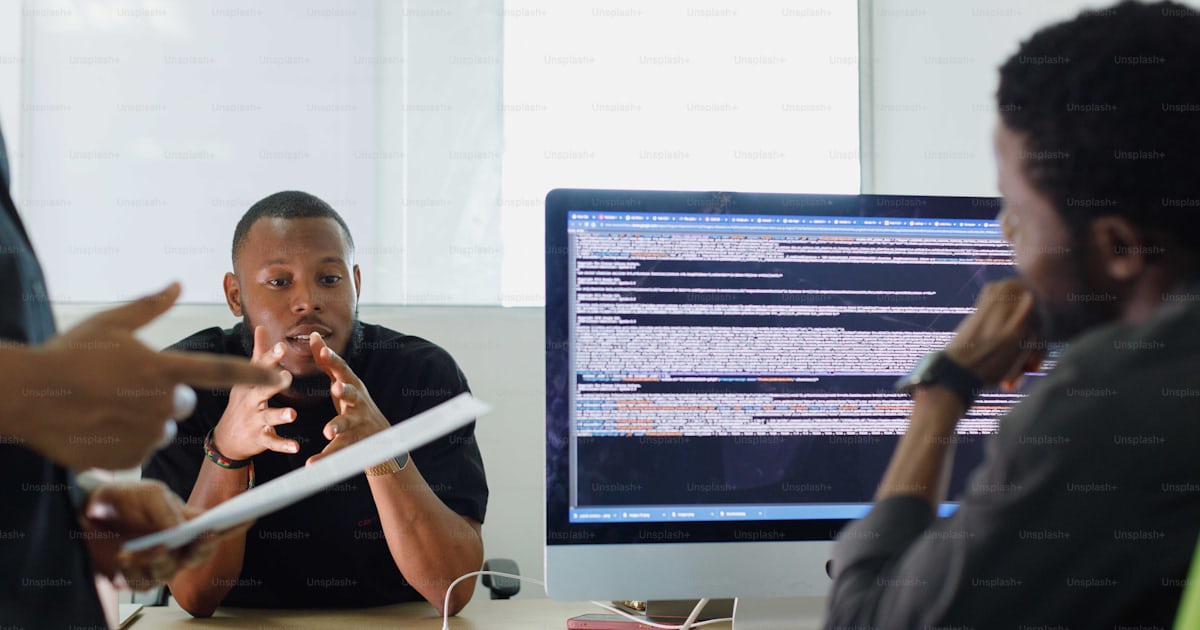 A group of people sitting around a computer photo – Web design Image on ...