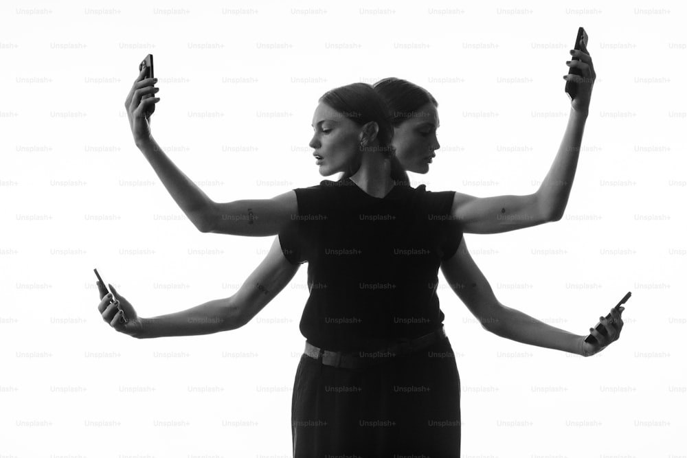 a black and white photo of two women holding cell phones