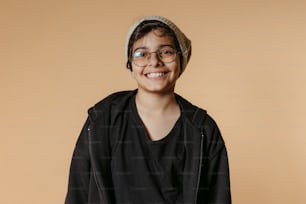 a young boy wearing glasses and a hat