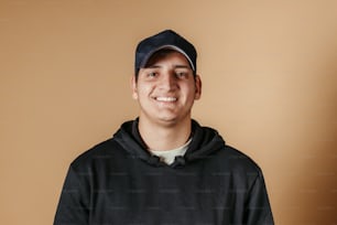 a man in a black hoodie and a baseball cap