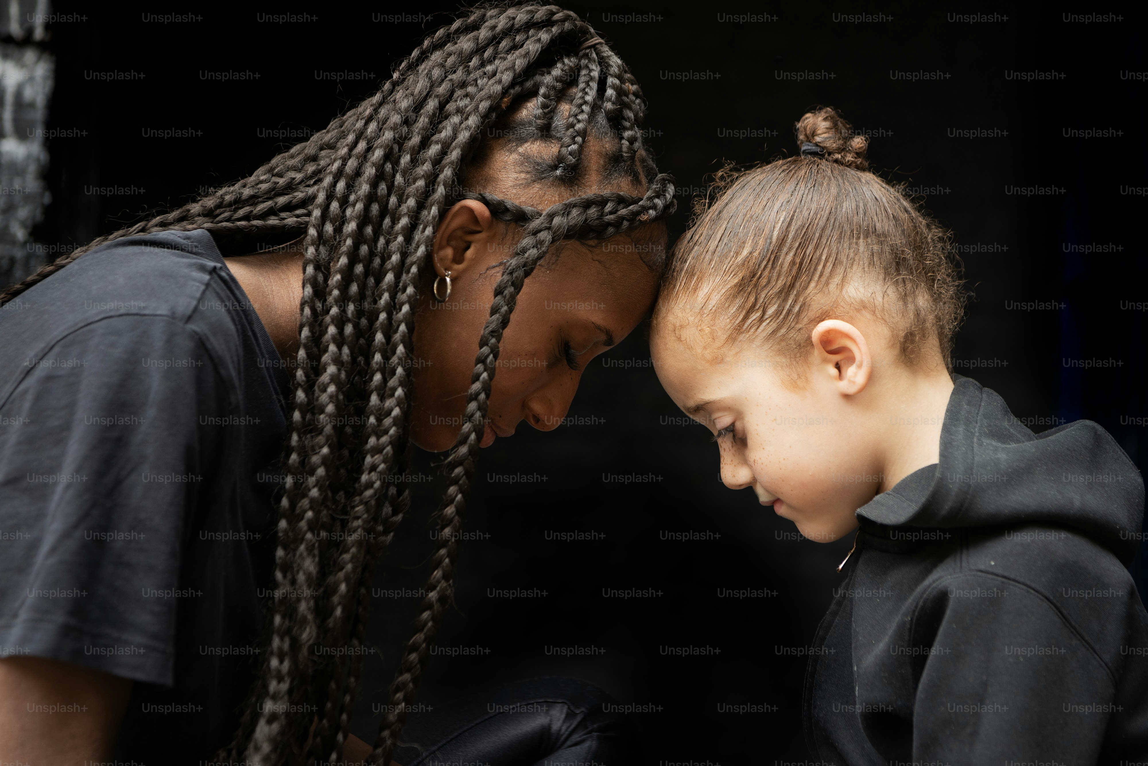 a woman and a child looking at a cell phone