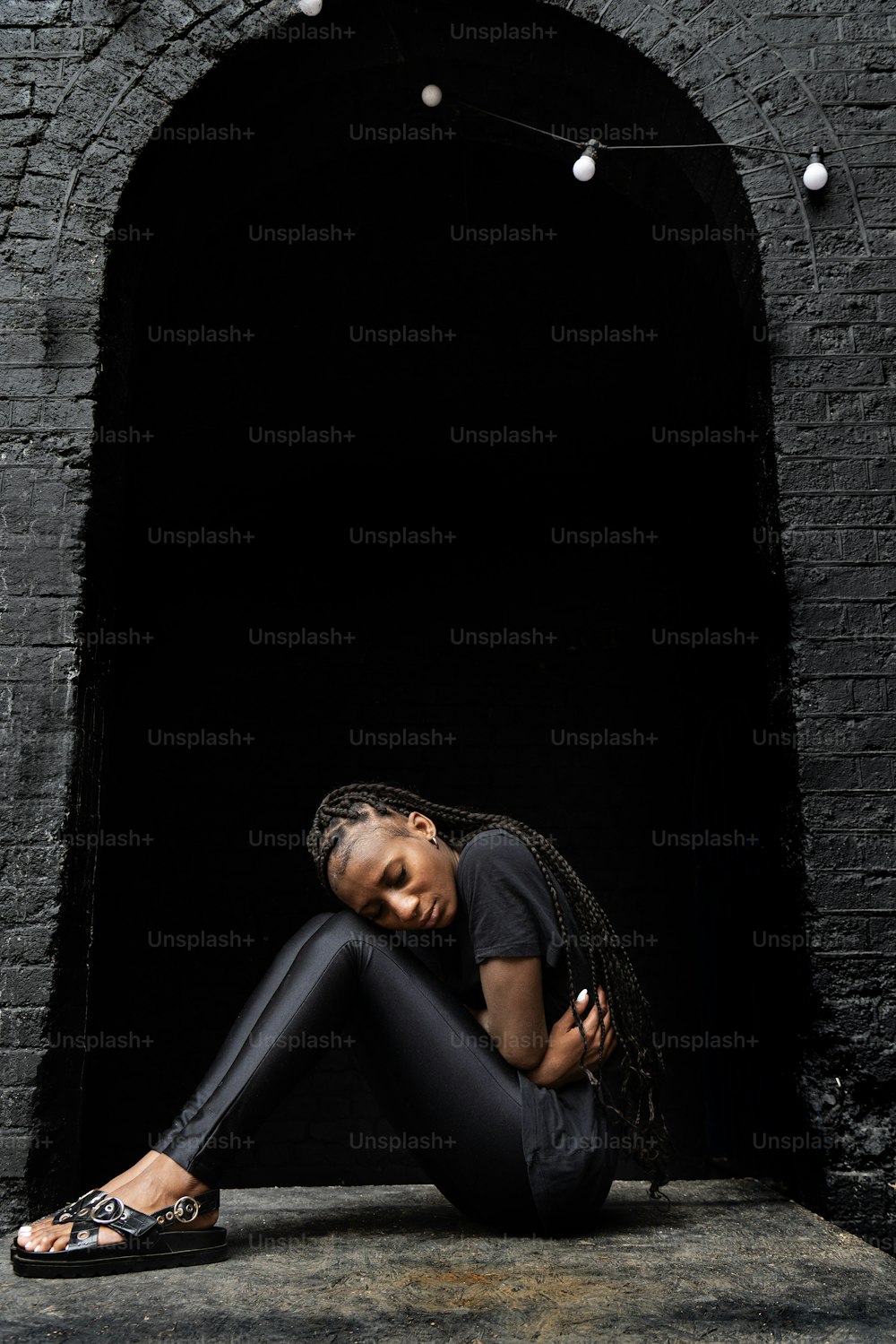 Una donna seduta a terra in un tunnel