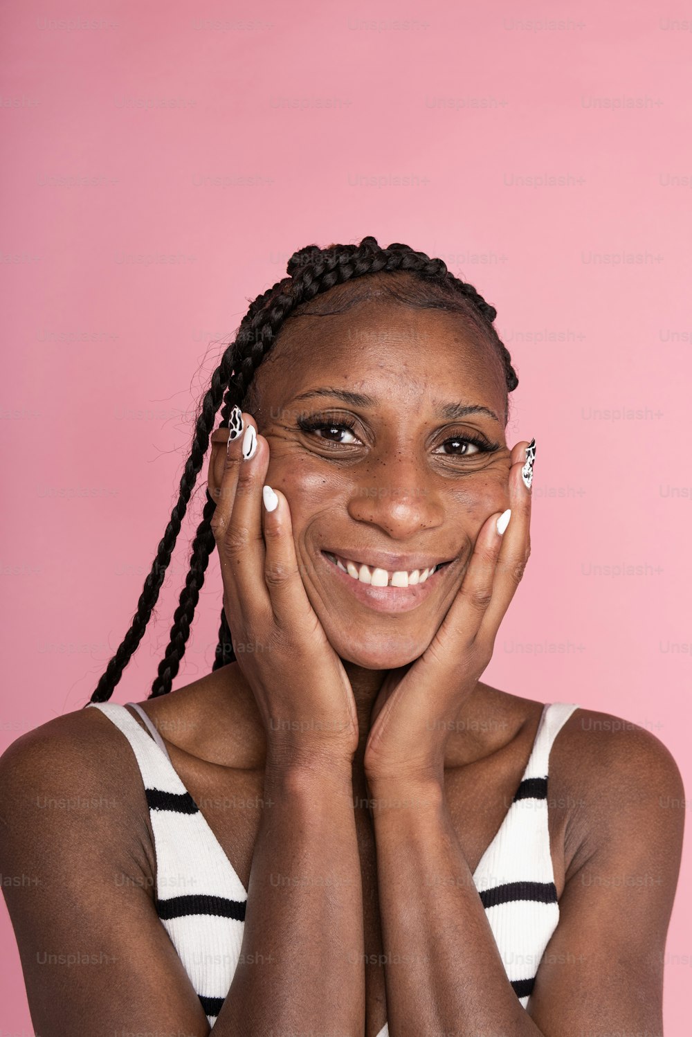 Une femme souriante avec ses mains sur son visage