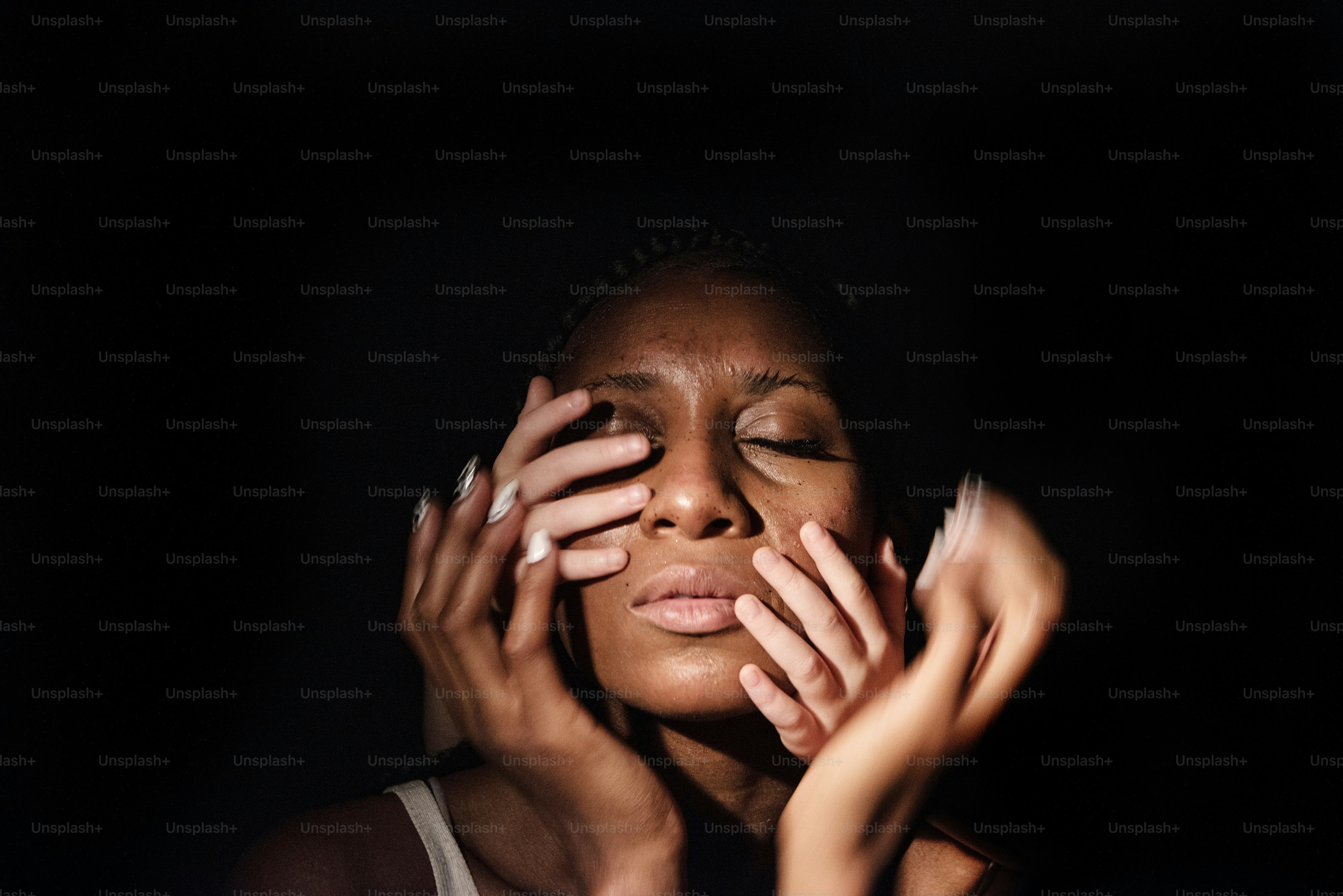 a woman holding her hands up to her face