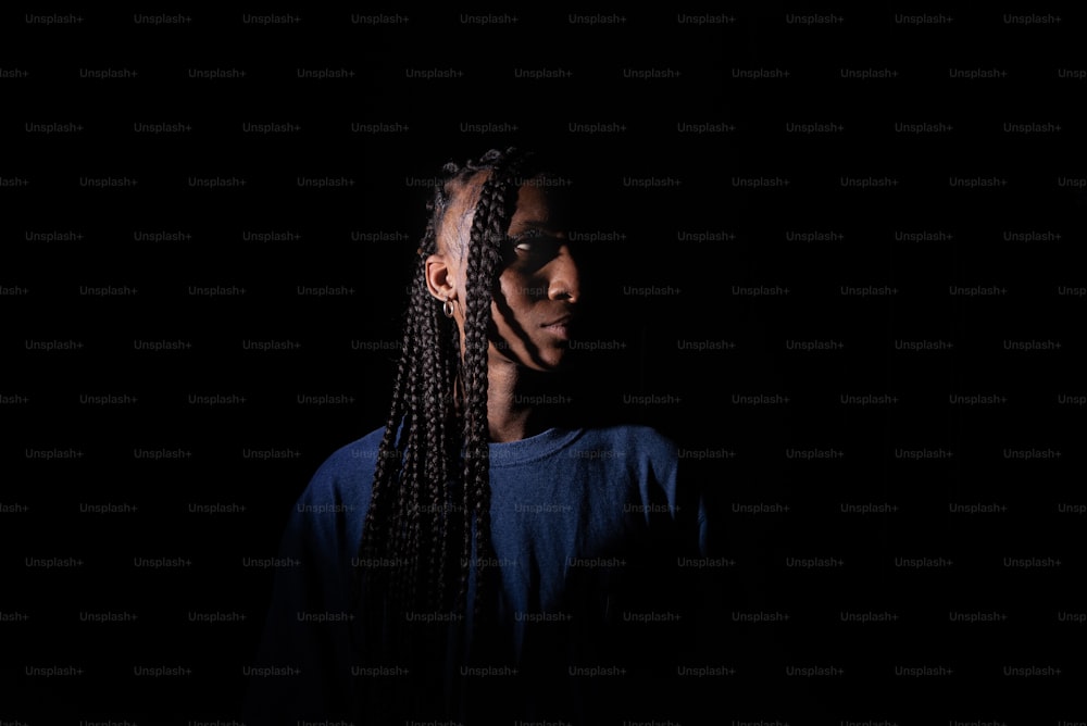 a woman with long braids standing in the dark
