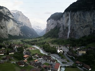 a valley with houses and a waterfall in the background