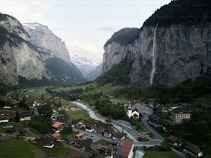 Un valle con casas y una cascada al fondo