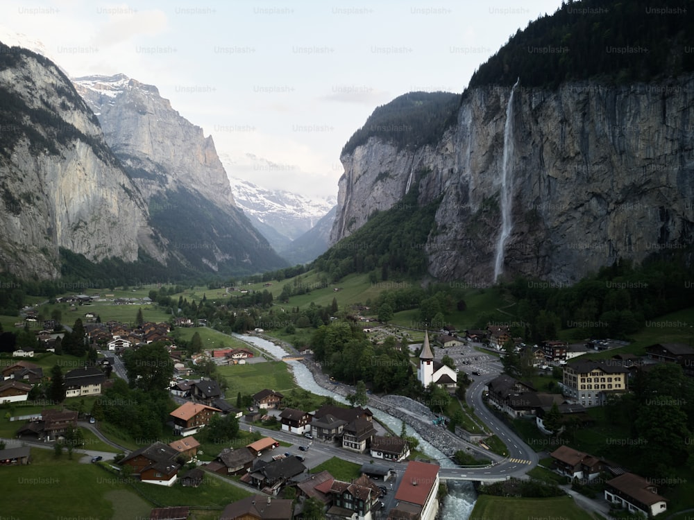 a valley with houses and a waterfall in the background