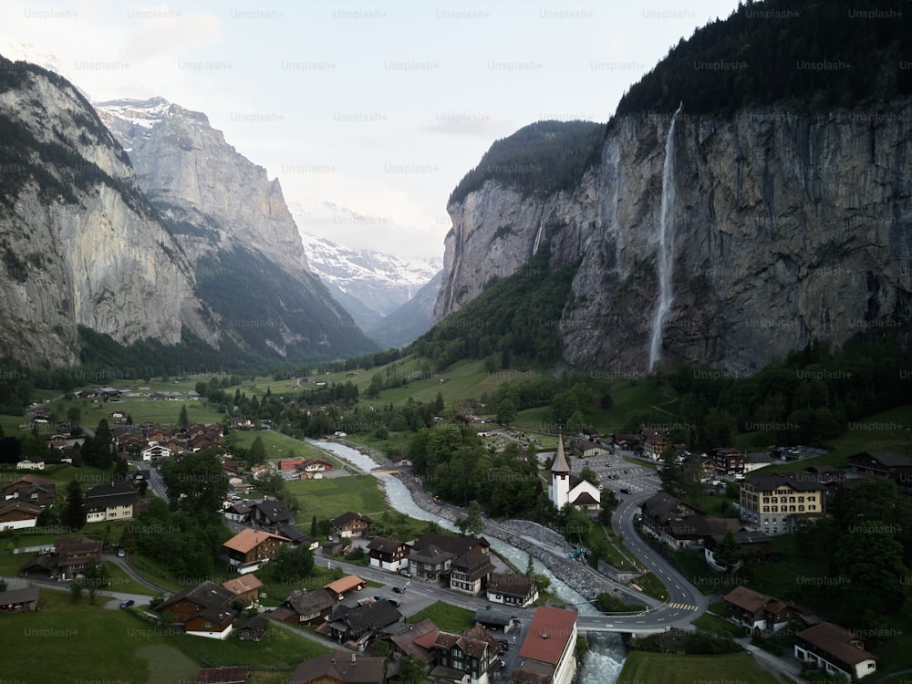 ein Tal mit Häusern und einem Wasserfall im Hintergrund