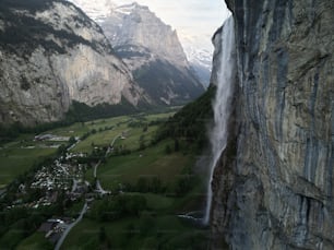 a view of a valley and a waterfall from a high cliff