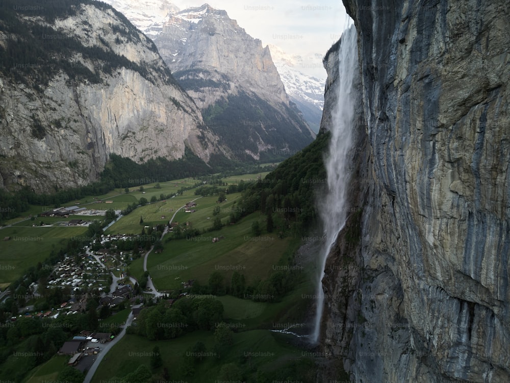 Una vista de un valle y una cascada desde un alto acantilado