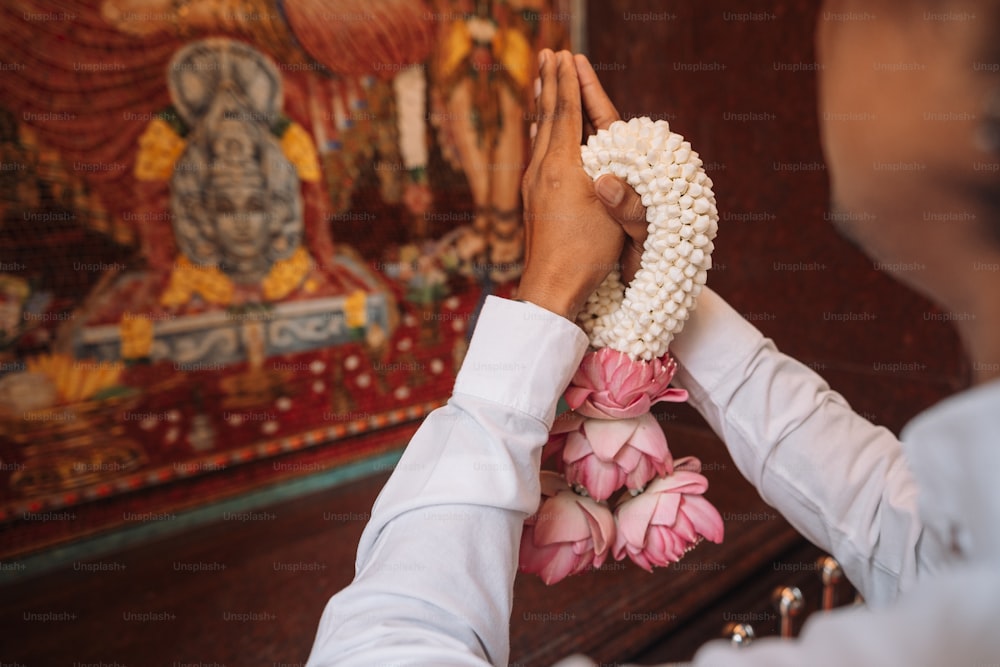 a woman is placing flowers on a man's head