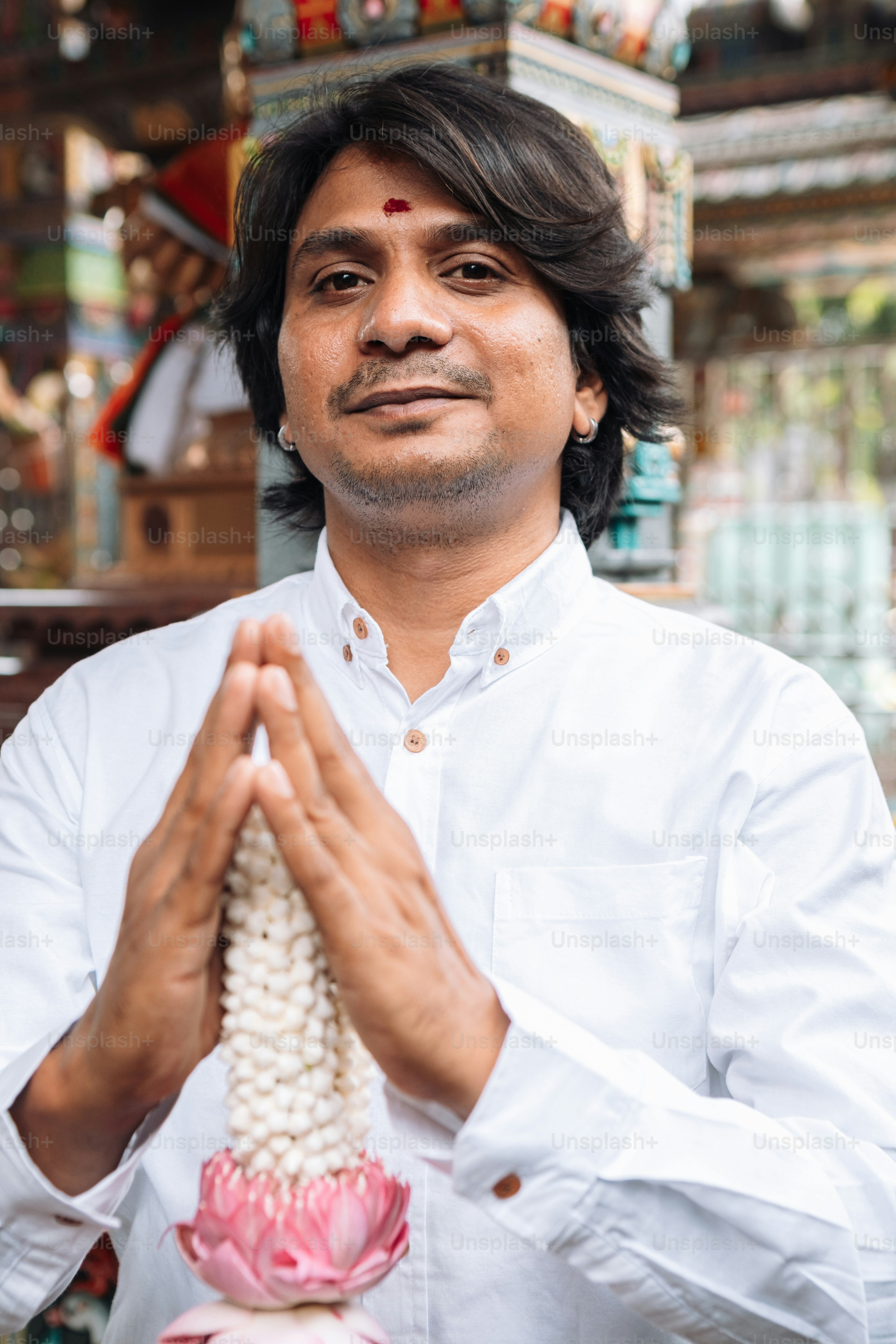 a man in a white shirt is holding a flower