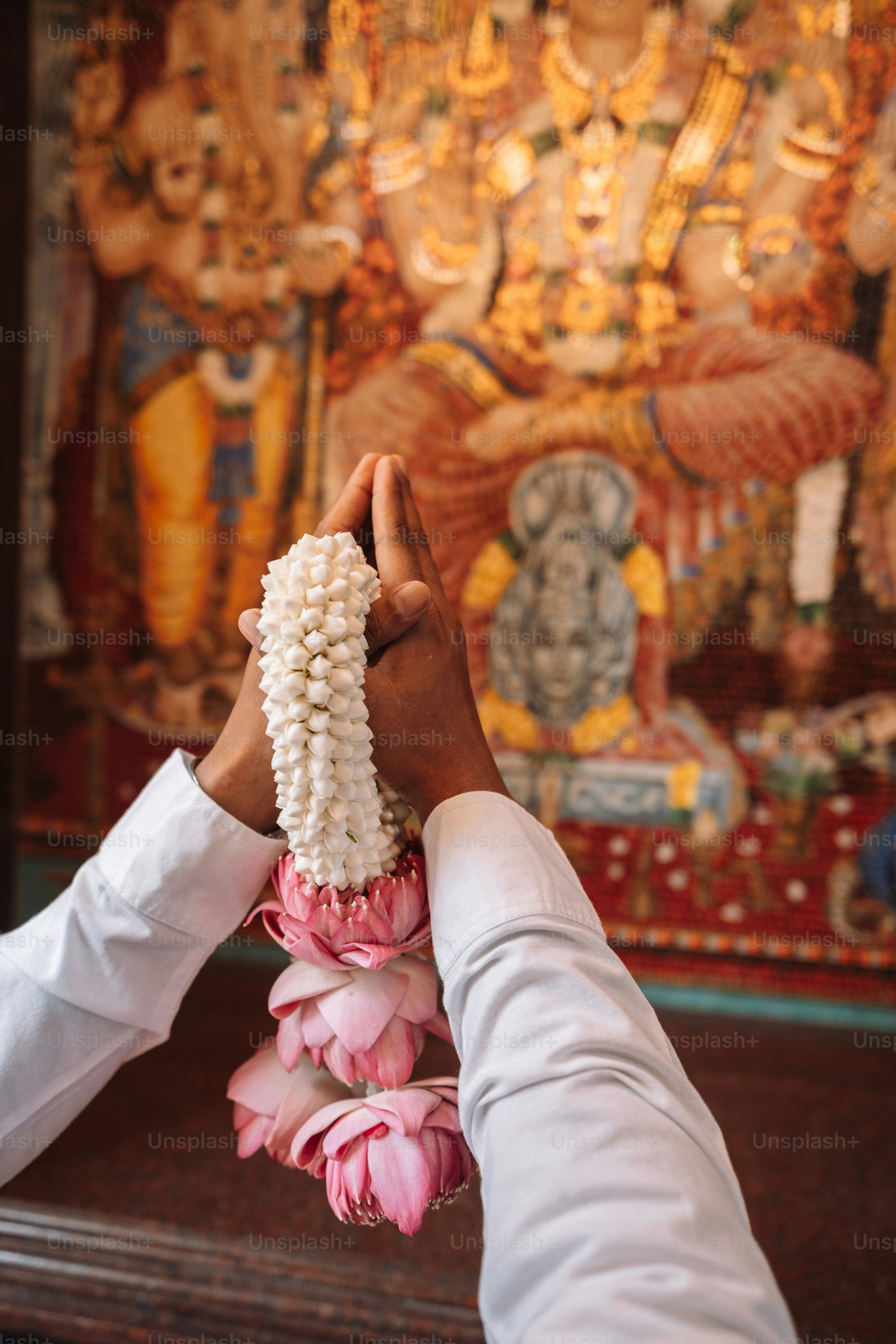a person holding a bunch of flowers in front of a painting