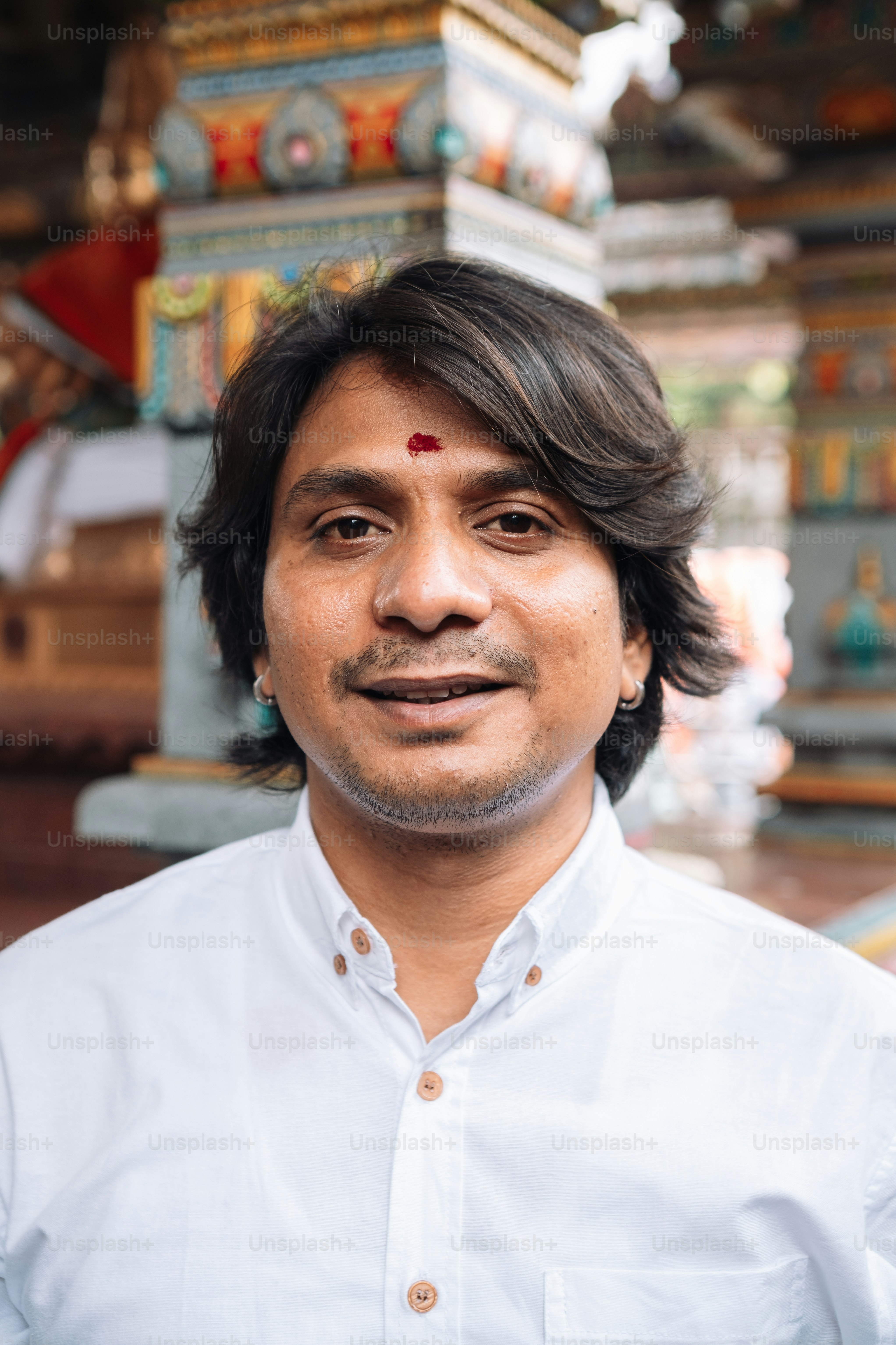 a man in a white shirt standing in front of a temple