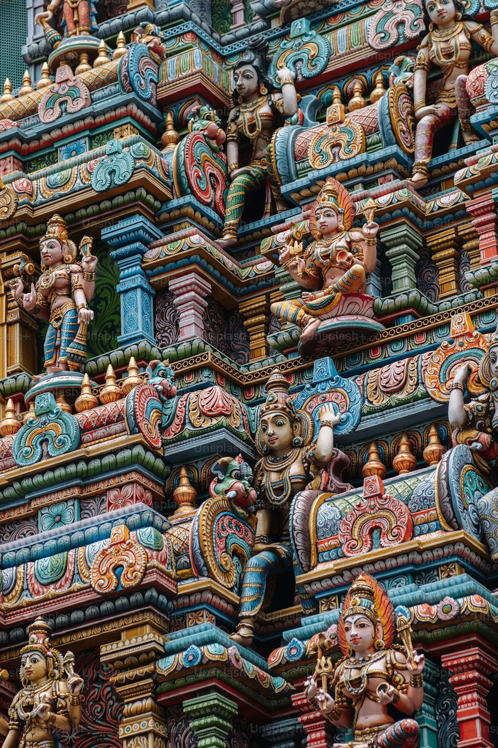 a close up of a colorful building with statues on it