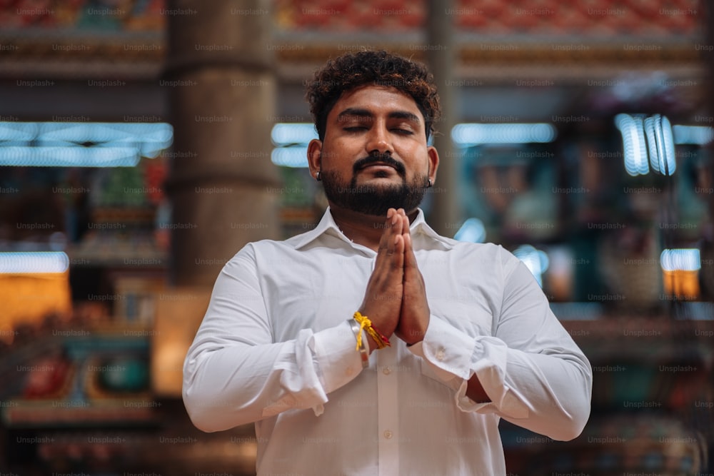 a man in a white shirt is praying