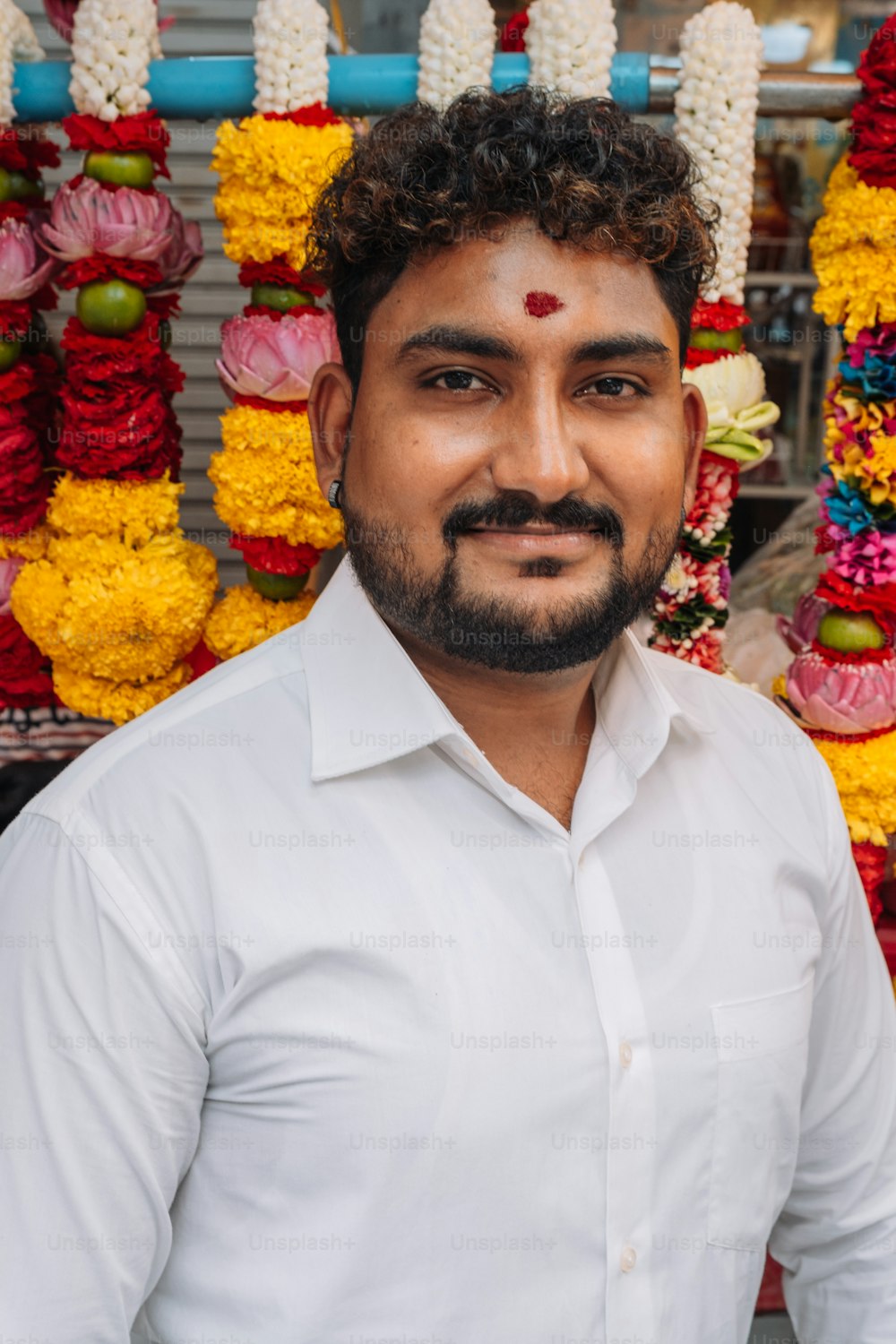 a man standing in front of a bunch of flowers