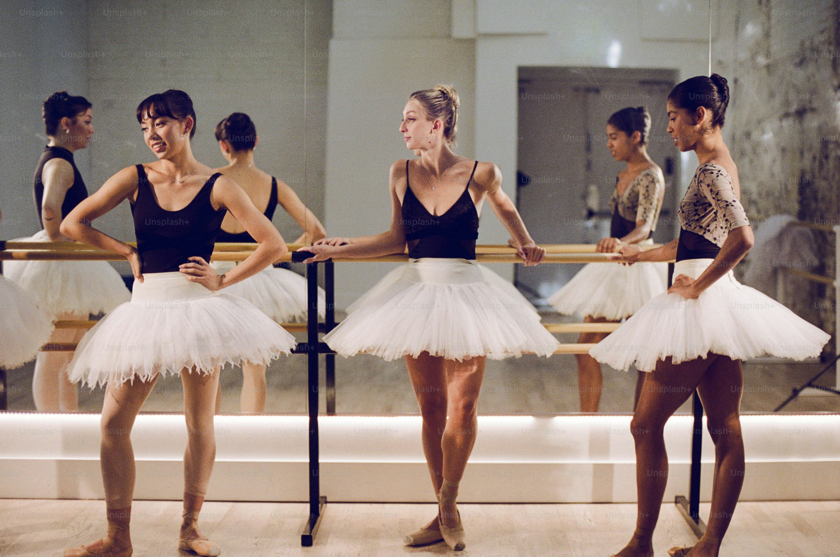 Eine Gruppe von Ballerinas, die vor einem Spiegel stehen