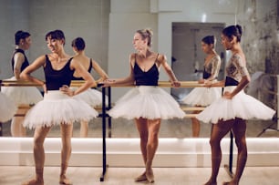 a group of ballerinas standing in front of a mirror