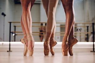 Drei Ballerinas stehen in einem Ballettstudio