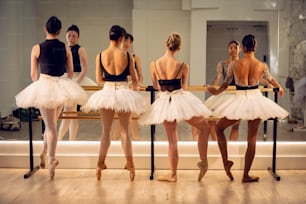Eine Gruppe von Ballerinas, die vor einem Spiegel stehen
