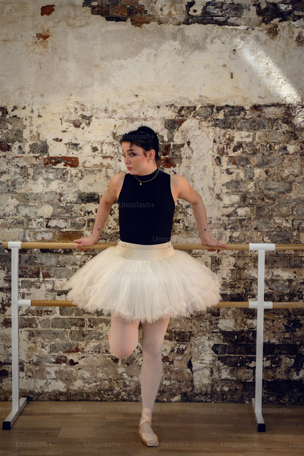 a woman in a white tutu and a black tank top